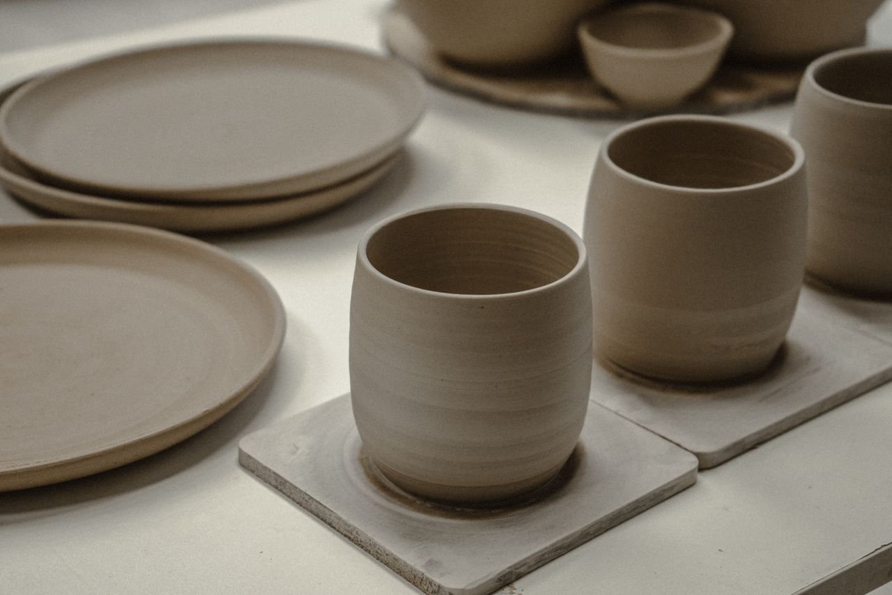Home Showcasing a collection of handmade ceramic mugs and plates with a minimalist design.